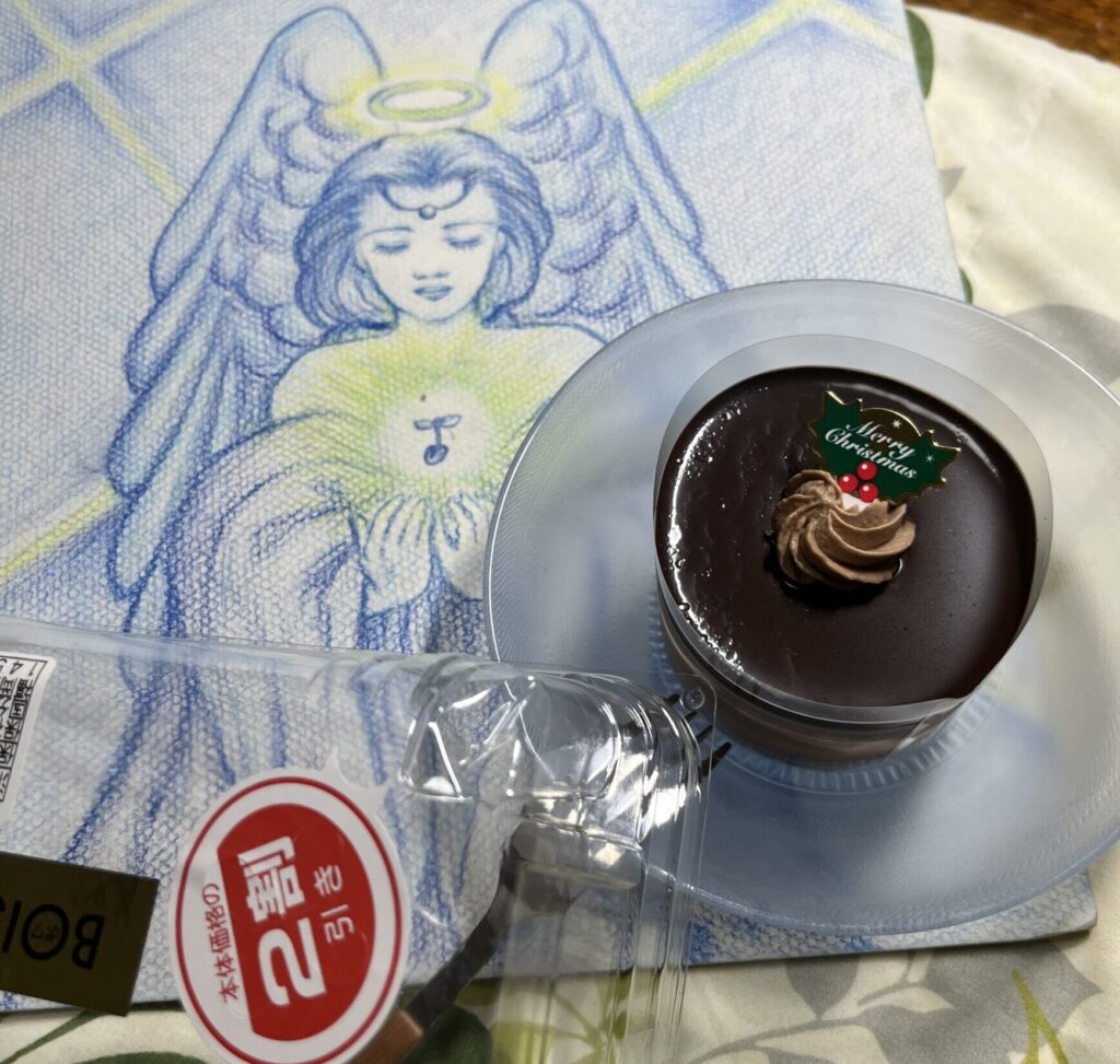 手書き天使の絵の上にチョコレートケーキ