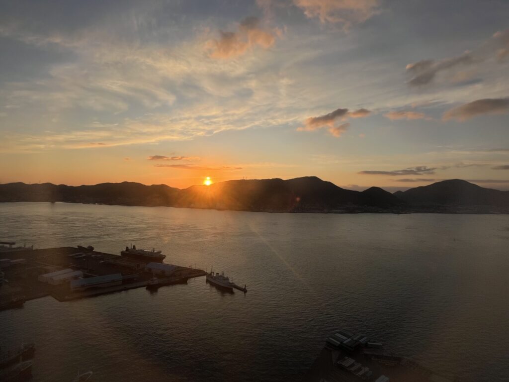 山間から太陽が顔を出した風景