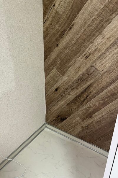 壁の黒カビ除去後の状態。防カビ処理と木目調シートの部屋の角。