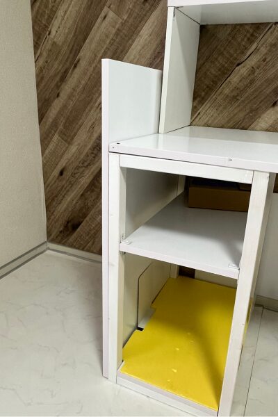 枠組みを木柱で組み、その上に白いカラー化粧板を載せた手作りの棚。